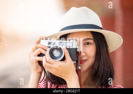 Donne asiatiche turisti portare una fotocamera e sorridente brillantemente presso la stazione ferroviaria. Foto Stock