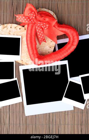 Vecchie foto vuote e cuore decorativo su sfondo legno colore Foto Stock