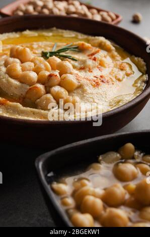 Vista da vicino a Hummus con fagioli olio d'oliva e foglie di rosmarino verde sul tavolo da cucina Foto Stock