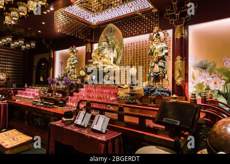 Singapore, 2019 ottobre: All'interno del Tempio Reliquico del dente del Buddha a Chinatown. Statue di Buddha d'oro e altare decorativo Foto Stock