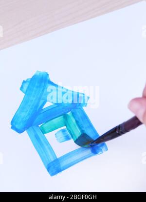 Il bambino disegna la casa con acquerelli, primo piano Foto Stock