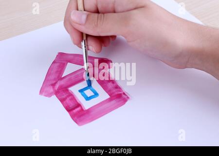 Il bambino disegna la casa con acquerelli, primo piano Foto Stock
