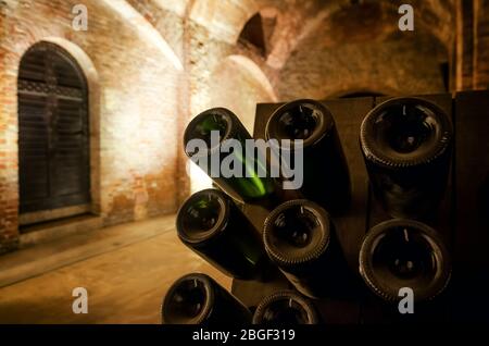 Pupitre e bottiglie all'interno di una cantina sotterranea per la produzione di spumanti metodo tradizionale in italia Foto Stock
