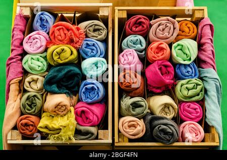 molti foulard di pashmina arrotolati in casse di legno di un mercato stalla Foto Stock