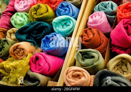 molti foulard di pashmina arrotolati in casse di legno di un mercato stalla Foto Stock