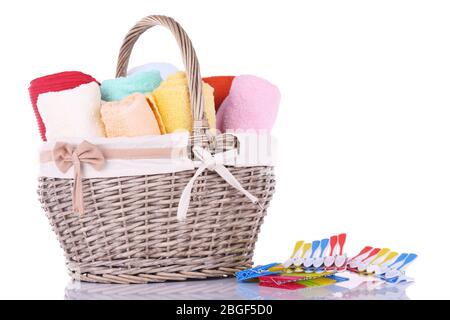 Asciugamani colorati in cesto, spille e liquido per il lavaggio, isolati su bianco Foto Stock