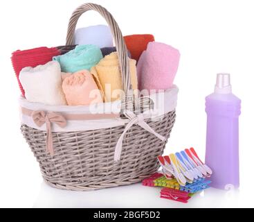 Asciugamani colorati in cesto, spille e liquido per il lavaggio, isolati su bianco Foto Stock