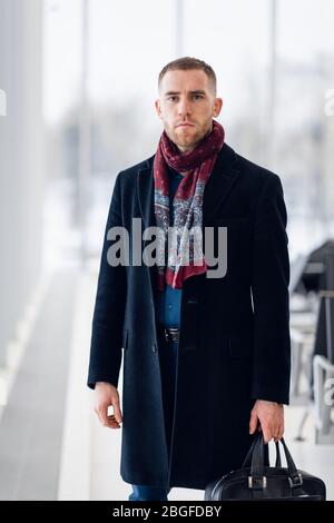 Uomo d'affari seduto al salotto d'attesa dell'aeroporto e in attesa del volo. Dirigente maschile nella business lounge dell'aeroporto, seduto nell'area d'attesa. Foto Stock