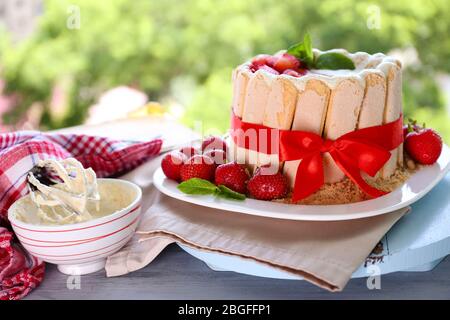 Torta gustosa Charlotte con fragole fresche su sfondo verde natura Foto Stock