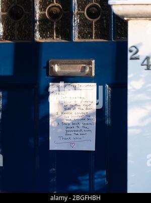 Un avviso sulla porta d'ingresso con istruzioni per consegne sicure durante la crisi di contagio Covid-19 a Ealing, Londra. Data foto: Domenica 19 aprile 2 Foto Stock