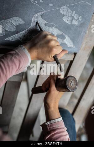Un artista di pietra al lavoro. Foto Stock