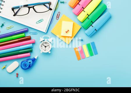 I materiali per ufficio si trovano su uno sfondo blu. Per studiare a scuola. Colore arcobaleno. Spazio libero Foto Stock