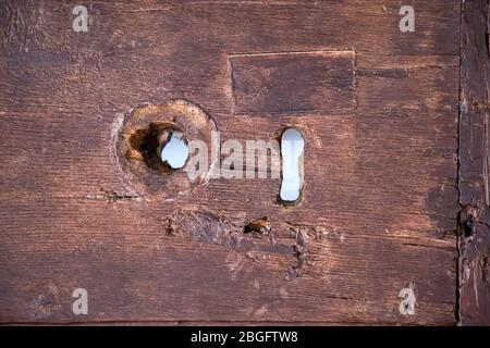 Serratura a chiave su vecchia porta di legno marrone Foto Stock