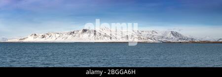 Panorama della baia di Faxaflói, Reykjavik, Islanda, che guarda attraverso le montagne coperte di neve in una giornata di sole Foto Stock