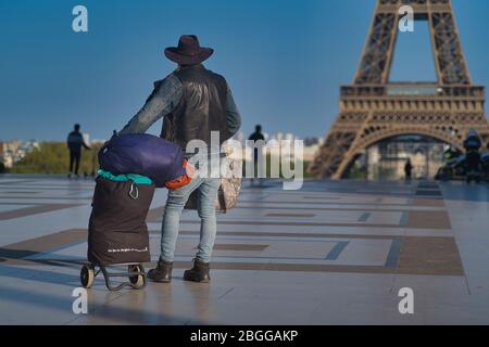 Un uomo solitario che guarda la Torre Eiffel a Parigi in Francia durante il blocco del Covid-19. E' una struttura incredibile e una meraviglia del mondo. Foto Stock