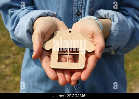 Donna tiene piccola casa di legno. Acquisto di una proprietà Foto Stock