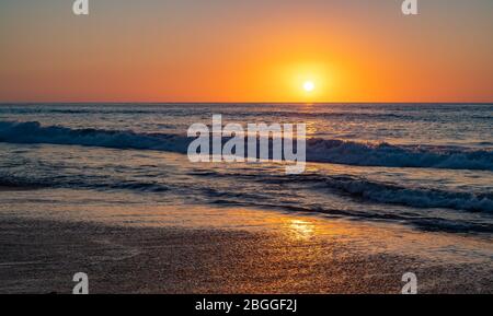 Alba colorata sul mare blu profondo Foto Stock