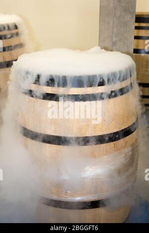 cantina ghiaccio secco bianco fumo in botte di legno raccolto per rinfrescare le uve durante la fermentazione Foto Stock