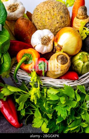 Vista ravvicinata del cesto di vimini pieno di verdure fresche e radici Foto Stock