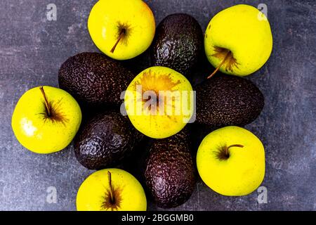 Mele verdi e avocado su superficie nera Foto Stock