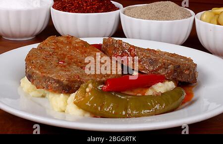perfetto cibo turco arrostire polpette piccanti su piatto bianco primo piano su tavolo di legno Foto Stock