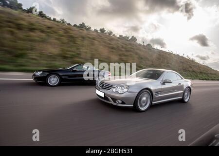 Auto da caccia argentata e nera sulla strada di montagna, attraverso le Highlands Foto Stock