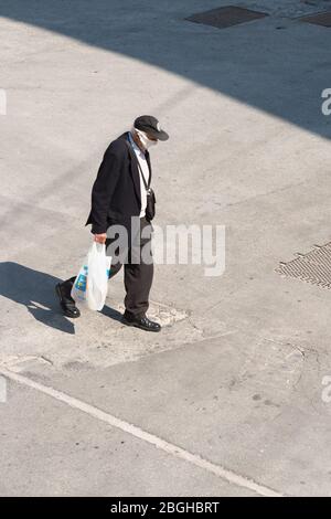 Campobasso, Regione Molise, Italia: Un uomo cammina per strada indossando la maschera di protezione durante l'emergenza del coronavirus in Italia. Foto Stock