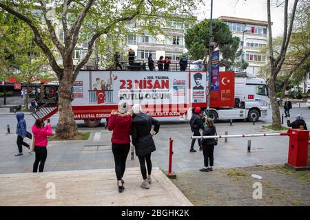 Istanbul, Turchia. 21 Apr 2020. La banda morale del comune di Kadikoy ha dato morale al pubblico con la loro musica su Bagdat Street alla vigilia del 23 aprile, la sovranità nazionale e la festa dei bambini, Kadikoy. Mentre la banda morale diede morale alle persone che chiudevano le loro case a causa della pandemia di Coronavirus, iniziarono il centenario della sovranità nazionale e della Giornata dei bambini all'inizio della settimana. La sovranità nazionale e la Giornata dei bambini è una festa pubblica in Turchia, che celebra la fondazione della Grande Assemblea Nazionale della Turchia, il 23 aprile 192 Foto Stock