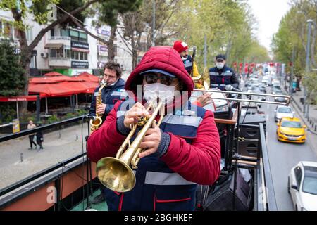 Istanbul, Turchia. 21 Apr 2020. La banda morale del comune di Kadikoy ha dato morale al pubblico con la loro musica su Bagdat Street alla vigilia del 23 aprile, la sovranità nazionale e la festa dei bambini, Kadikoy. Mentre la banda morale diede morale alle persone che chiudevano le loro case a causa della pandemia di Coronavirus, iniziarono il centenario della sovranità nazionale e della Giornata dei bambini all'inizio della settimana. La sovranità nazionale e la Giornata dei bambini è una festa pubblica in Turchia, che celebra la fondazione della Grande Assemblea Nazionale della Turchia, il 23 aprile 192 Foto Stock