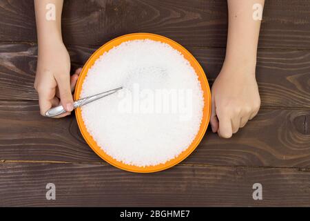 Un bambino mangia i pellets di plastica da un plate.concept di inquinamento ambientale con la plastica Foto Stock