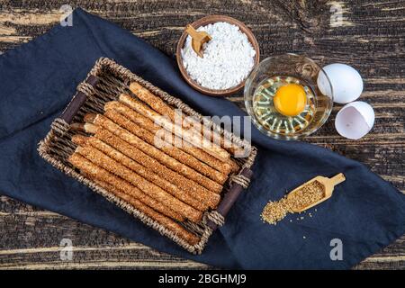 Bastoncini di pane fatti in casa con semi di sesamo su sfondo di legno. Messa a fuoco selettiva Foto Stock