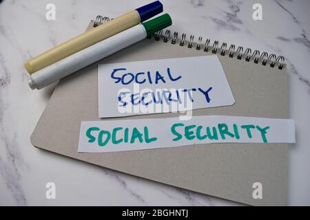 Scrivere sulla previdenza sociale su un libro isolato su Office Desk. Foto Stock