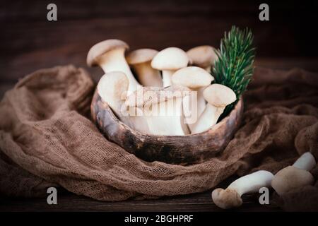 Funghi porcini di ostrica reale pleurotus eryngii su sfondo marrone. Stile rustico Foto Stock