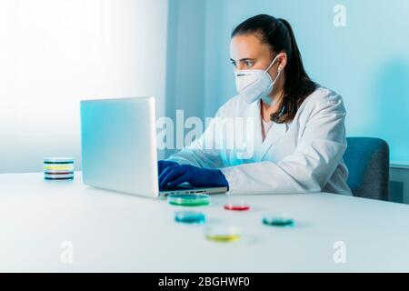 Donna che lavora con Petri piatti in laboratorio. In cerca di vaccino per coronavirus. Laboratorio microbiologico. Foto Stock