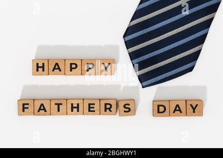 Blocchi per la Giornata dei Padri felici con cravatta su sfondo bianco. Sfondo dell'evento di celebrazione Foto Stock