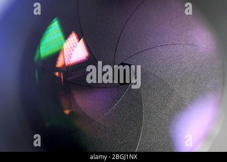 Concetto fotografico. Primo piano, diaframma di un obiettivo della fotocamera. Messa a fuoco selettiva con profondità di campo bassa . Foto Stock