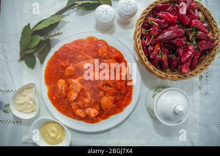 Pickle di pomodoro . Pollo e pomodori . Peperone secco rosso in cesto tradizionale . Pickle di pomodoro . Chakhokhbili - pollo stufato con pomodori e cipolle Foto Stock