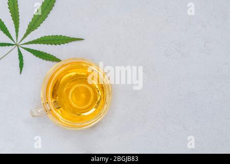 La cannabis ha infuso il tè in una tazza di vetro. Vista dall'alto con spazio per le copie Foto Stock