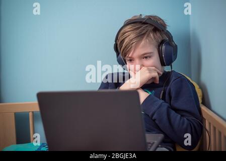 Bambino che studia da casa in mezzo alla crisi del coronavirus COVID-19 Foto Stock