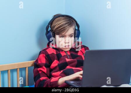 Bambino che studia da casa in mezzo alla crisi del coronavirus COVID-19 Foto Stock