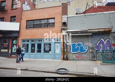 New York, New York, Stati Uniti. 17 Aprile 2020. Donne che indossano maschere camminano nei negozi chiusi in Canal Street a Manhattan. La maggior parte dei negozi di New York sono saliti a bordo e chiusi per affari, con certezza di quando riapriranno. Con l'aumento del numero di vittime dello stato di New York a causa dell'epidemia di coronavirus, i newyorkesi continuarono a combattere contro il COVID-19 attraverso l'isolamento sociale e l'autoquarantena, rendendo le strade e le aree pubbliche tipicamente trafficate della città silenziose. Credit: Jodi Jones/ZUMA Wire/Alamy Live News Foto Stock