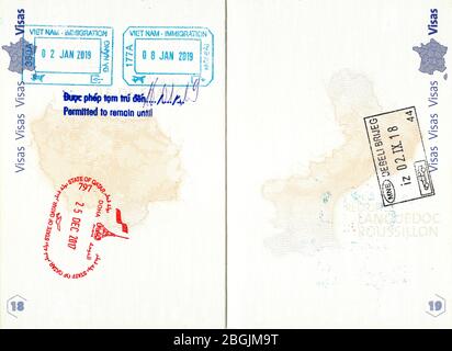 Francobolli di Vietnam, Qatar e Montenegro in un passaporto francese Foto Stock