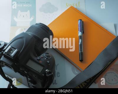 installazione da tavolo per fotografi microstock con fotocamera, penna e note Foto Stock