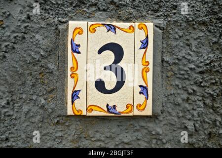 Numero 3, cifra tre, piastrelle decoratice su sfondo grigio. Foto Stock