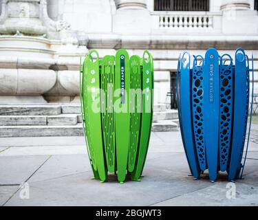 Riciclare le lattine in verde brillante e blu in un'area urbana per uso misto. Foto Stock