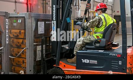 Soldato della Guardia Nazionale dell'Oregon. Adrian Muñoz Gonzalez, insieme al personale del Dipartimento per gli standard e la formazione sulla pubblica sicurezza (DPSST), carica 140 ventilatori Oregon su un camion per la spedizione a New York., 6 aprile 2020. (Foto della Guardia Nazionale dell'Oregon Army di Sgt. Prima Classe Zachary Holden, Oregon Military Department Public Affairs) Foto Stock