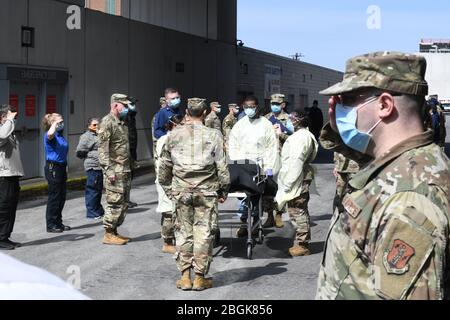 Il personale militare e civile che lavora alla Javits New York Medical Station, eretta al Jacob Javits Convention Center di New York, rende onore militare a un veterano morto di COVID19 mentre un paziente alla stazione medica il 19 aprile 2020. I membri dell'esercito attivo e della Guardia Nazionale di New York militari e civili con membri di servizio precedenti dell'esercito hanno preso parte al riconoscimento come i suoi resti sono stati trasferiti.(foto della Guardia Nazionale dell'aria degli Stati Uniti dal maggiore Patrick Cordova) Foto Stock