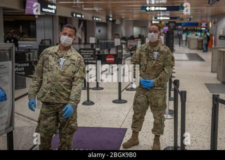 I soldati della Guardia Nazionale delle Hawaii (HING) hanno messo in scena al checkpoint di screening medico nel Terminal 1 all'Aeroporto Internazionale Daniel K. Inouye, 6 aprile 2020, Honolulu, Hawaii. I soldati HING assistono l'aeroporto di incendio con lo screening del 100% dei passeggeri in arrivo e in partenza durante la risposta COVID-19. (STATI UNITI Foto della Guardia Nazionale dell'esercito di Sgt. John Schoebel) Foto Stock