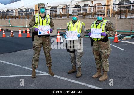 I militari e i militari della Guardia Nazionale del Massachusetts scattano una foto che rispondono insieme per aiutare le loro comunità durante la risposta del COVID-19. Forze di sicurezza Airmen della 104th Fighter Wing, Barnes Air National Guard base, Mass., e soldati con la 747th Military Police Company, Massachusetts Army National Guard, stanno fornendo 24 ore di sicurezza per i siti di test e rifugi per i senzatetto che possono essere positivi COVID-19. Gli Airmen e i Soldiers stanno lavorando con i partner interagency Springfield Police Department per garantire la sicurezza e la sicurezza per le forniture, i pazienti e il personale. Massa Foto Stock