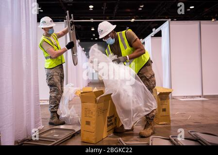 I membri della Guardia Nazionale dell'aria dell'Illinois assemblano le attrezzature al Centro Congressi McCormick Place in risposta alla pandemia COVID-19 a Chicago, Ill., 8 aprile 2020. Circa 60 membri della Guardia Nazionale dell'aria dell'Illinois sono stati attivati per supportare il corpo degli ingegneri dell'esercito degli Stati Uniti e la Federal Emergency Management Agency (FEMA) per convertire temporaneamente parte del McCormick Place Convention Center in una struttura di cura alternativa (ACF) per i pazienti con COVID-19 con sintomi lievi che lo fanno Non richiedono cure intensive nella zona di Chicago. (STATI UNITI Air Force Foto di Senior Airman Jay Grabiec) Foto Stock